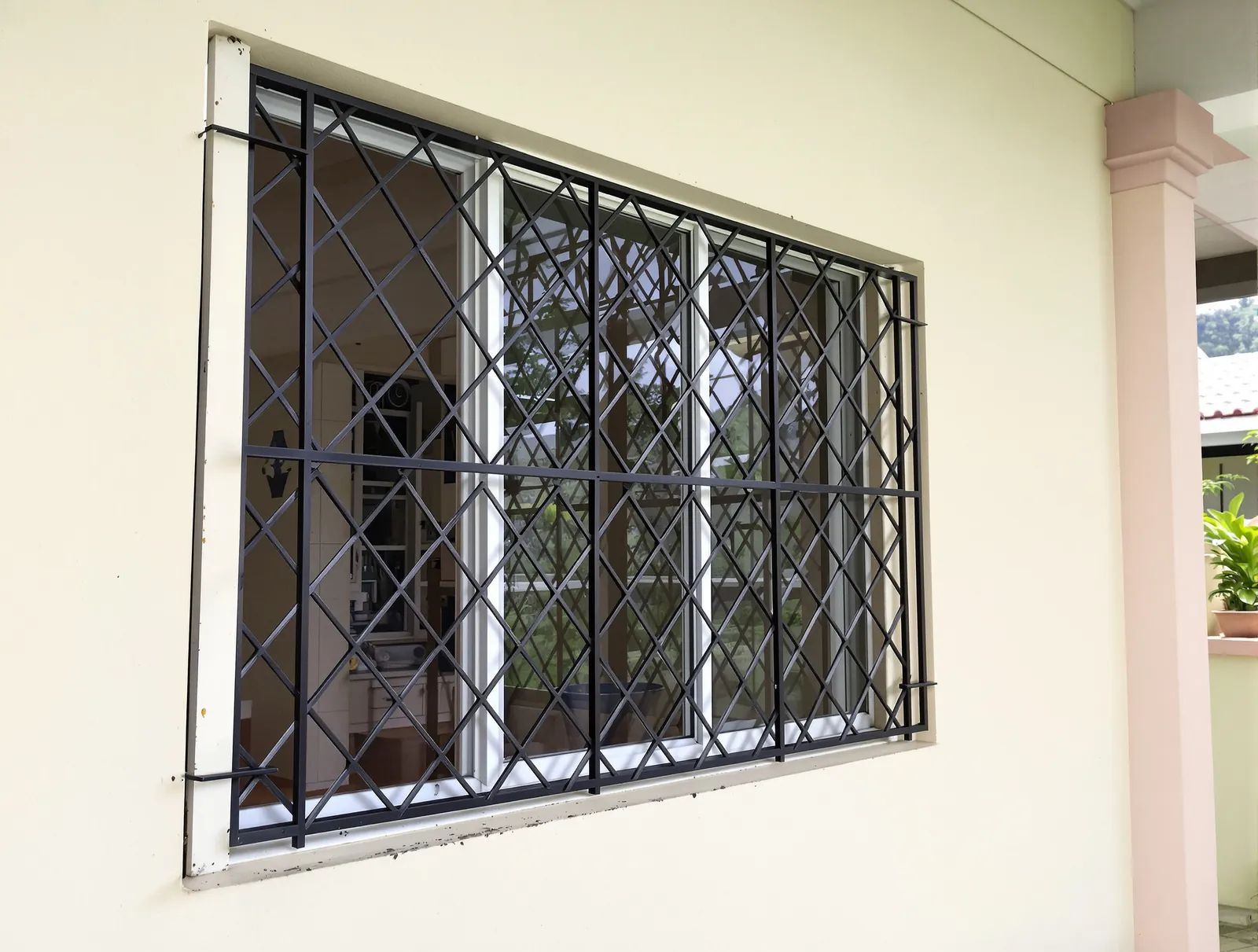 Black steel window grill with a diagonal diamond lattice