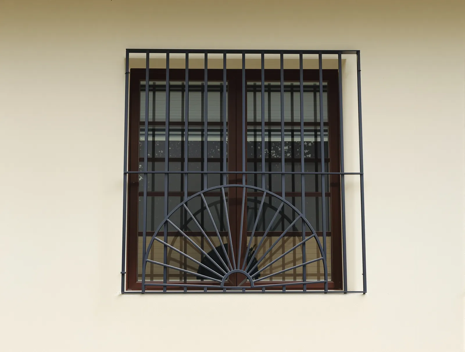 Window grill with a half sunburst at the bottom